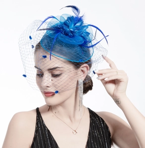 Detail of blue mesh bridal fascinator with elegant feathers and soft pom-pom accents