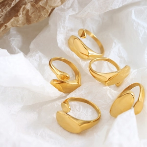 Set of minimalist 18k gold irregular rings on artistic paper background display
