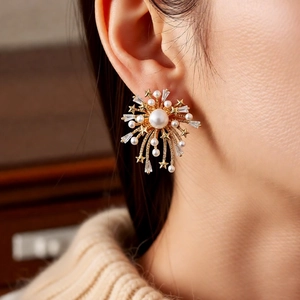 Detailed view of 18k gold plated firework earring with pearl and zircon on model