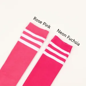 Detail of rose red and fluorescent rose red over-the-knee socks with white stripes