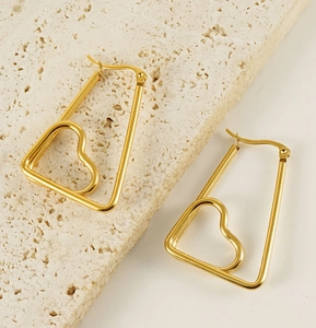 Detailed close-up of golden stainless steel earrings with heart design on stone