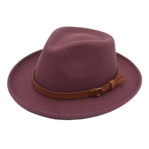 Close-up of burgundy fedora hat with brown leather band and gold buckle detail