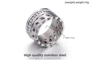 Dettaglio anello largo in acciaio inossidabile con strass e motivi geometrici cavi