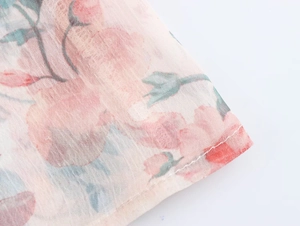 Close-up of floral chiffon fabric with delicate pink roses and high-quality stitching
