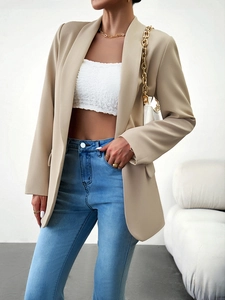 Détail d'un blazer beige avec fermeture à bouton unique et manches longues ajustées