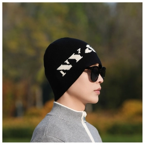 Detail of black knitted beanie featuring a large white NY logo and waffle texture fabric