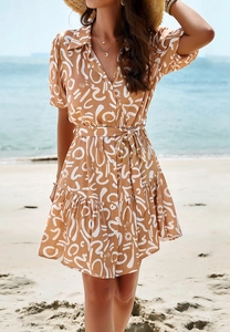 Elegant short sleeve shirt dress with abstract geometric print and waist tie at beach