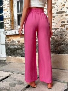 Détail du pantalon large rose à taille haute élastique montrant la coupe de dos