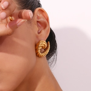 Macro shot of 18K gold plated spiral horn earrings worn for a modern stylish look