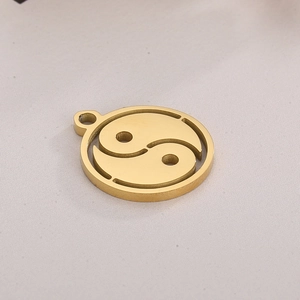 Golden hollow Yin Yang Tai Chi pendant accessory on soft fabric background
