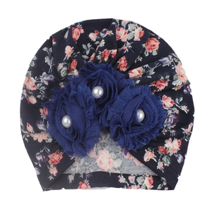 Detail of floral baby turban with dark blue silk flowers and white pearl center accents