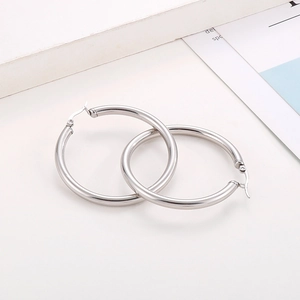 Macro detail of silver geometric hoop earrings with polished finish and secure clasp