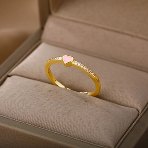 Close-up of a gold heart ring with pink stone and white zircons in a jewelry box