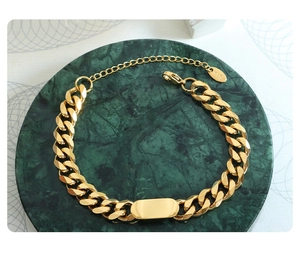 Gros plan d'un bracelet gourmette plaqué or 18 carats avec plaque rectangulaire et tag K18
