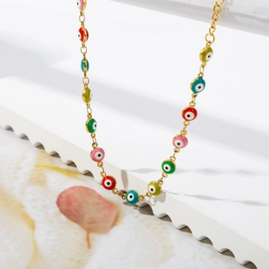 Detailed macro view of gold-plated stainless steel bracelet with colorful evil eye charms