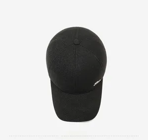Top view of a black winter baseball cap showing thick twill fabric and metal side detail