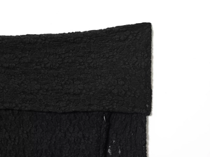 Close-up of black lace fabric showing intricate floral crochet patterns on the dress