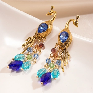 Macro view of vintage peacock earrings with blue gems and multicolored crystal tassels