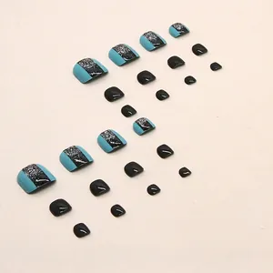 Lake blue and black glitter false toenails set arranged neatly on a plain background