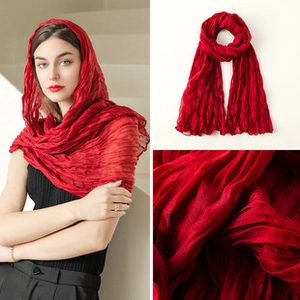 Close-up of bright red pleated scarf fabric texture and model wearing style details