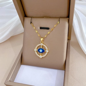 Detail of gold evil eye necklace with blue eye and crystals in a premium gift box
