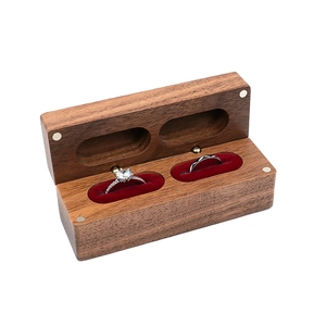 Macro view of walnut wood ring box with double red velvet slots and magnetic closure