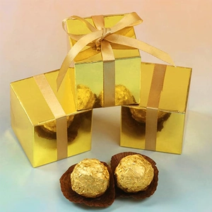 Detail van gouden vierkante snoepdoosjes met metallic glans en bijpassende satijnen linten