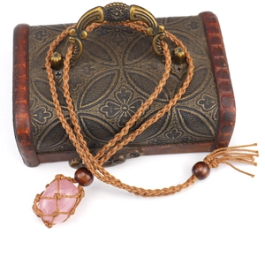 Detailed macro view of handmade woven net pouch necklace with polished pink crystal stone