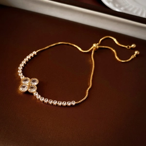 Macro detail of gold-plated clover bracelet with sparkling zircons and adjustable slider clasp
