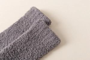 Close-up of grey fluffy coral fleece knee-high sock showing soft texture and elastic cuff
