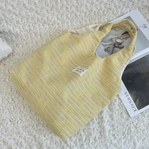 Detail of yellow tweed tote bag with woven colorful accents and zakka beauté label