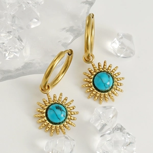 Golden sunburst hoop earrings with turquoise center stone set against clear ice cubes