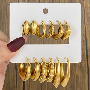 Detailed set of six pairs of gold geometric hoop earrings on a white display card