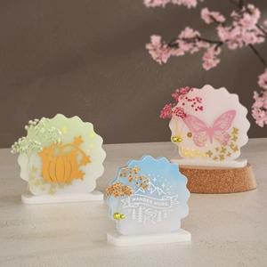 Macro view of acrylic decorative block with dried flowers and Wander More inscription