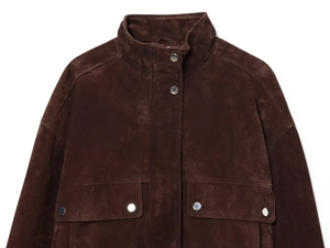 Detail of dark brown faux suede bomber jacket showing flap pocket with silver metal snap