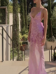 Detailaufnahme des funkelnden Kleides mit rosa-lila Pailletten und tiefem V-Ausschnitt