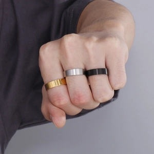 Minimalist 6mm titanium steel rings in gold, silver, and black on hand