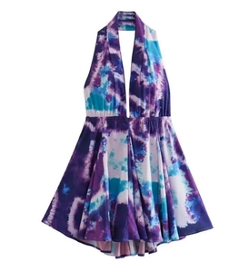Dettaglio di un abito allacciato al collo con stampa tie-dye e schiena scoperta viola