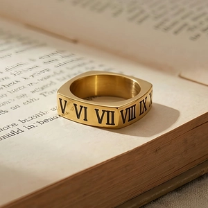 Macro di anello quadrato dorato con numeri romani su pagina di un vecchio libro