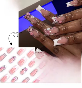 Detailed view of long coffin press-on nails with 3D floral accents and pink gradient tips