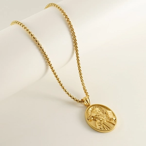 Gold St. Benedict religious pendant necklace with polished box chain on white display