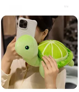 Peluche tortue verte avec carapace citron vert utilisée comme coussin d'épaule