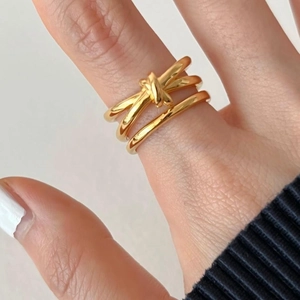 Macro shot of 925 silver knotted multi-layer gold ring worn on woman's index finger