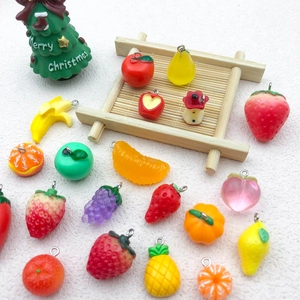 Flat lay of colorful resin fruit charms with metal rings for DIY jewelry making crafts