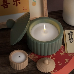 Détail de pots à bougies rayés vert sauge et beige avec texture nervurée verticale élégante