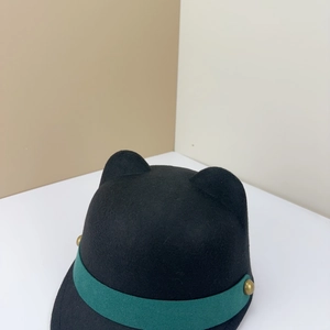 Detail of black wool equestrian hat featuring cat ears and green band with gold rivets