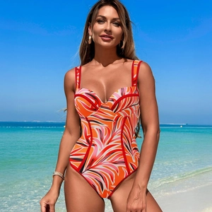 Detail of swimsuit with orange and pink leaf patterns, red piping and a cup structure