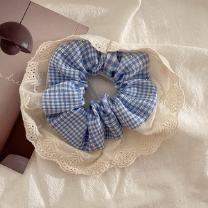 Dettaglio dello scrunchie a quadretti blu con perle d'argento e bordo in pizzo bianco