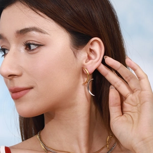 Women's celestial moon stud earrings in gold and silver finish on a female model