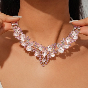Detailed view of pink teardrop crystal floral necklace on model's neckline